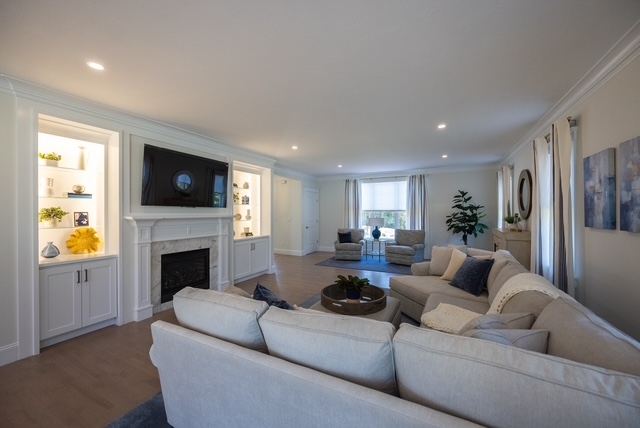 Open first-floor living room with gas fireplace and built-ins in a Trailside Estates 55+ luxury condominium