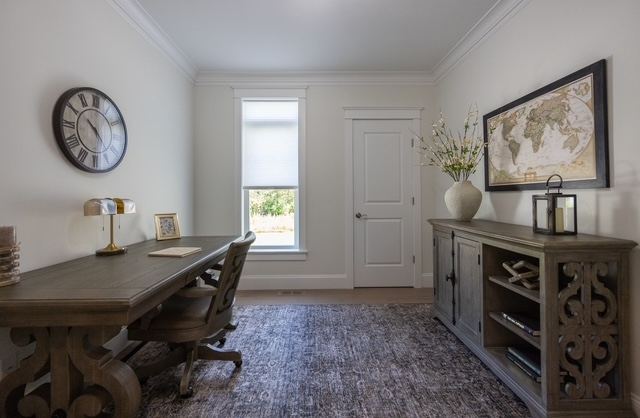 First-floor home office and flex room with built-in shelving inside a 55+ luxury condominium at Trailside Estates